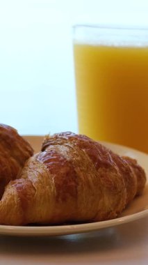 Kahvaltının yanında kahve, portakal suyu, kruvasan, mısır gevreği, çırpılmış yumurta ve krep var. Yüksek kalite 4k görüntü