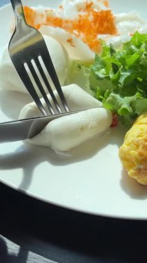 Vietnam usulü beyaz çörek peyniri. Açılmış kruvasan ve çırpılmış yumurta. Açısal beyaz tabakta. Bir kadın kruvasana taze çırpılmış yumurta koyuyor. Yüksek kalite 4k görüntü