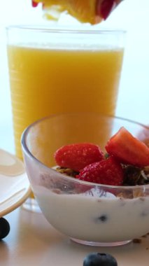 Kadın meyve sıkacağını renkli arka planda cama portakal suyu dolduruyor. Kafede turunçgil vitamik sağlıklı meyve suyu, sabah kahvaltısı içeceği. Yüksek kalite 4k görüntü