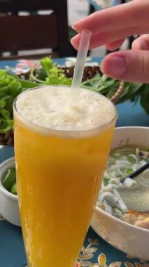 Otantik Burma hindistancevizli şehriye çorbası ve taze otlar. Asya mutfağı, canlı tatlar, kültürel yemek deneyimi. Açık havada tropikal meyve içeceği ve aşçılık lezzeti ile yemek. 4k