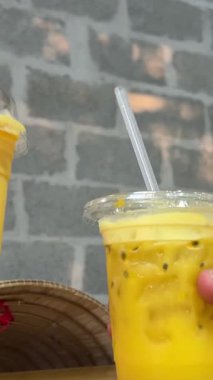 İki kişi, tapyoka incileriyle ev yapımı balonlu çayın çeşitliliğini birbirine tokuşturuyor. Limon, mango, arkaplanda meyve ve böğürtlenli ahududu çayı. Yüksek kalite 4k görüntü