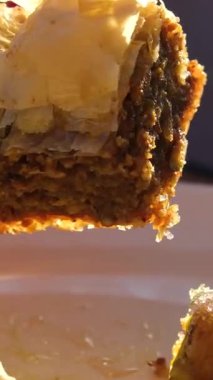 Altın baklava pişirme: Şam fıstığı ve bal şurubu içeren ağız sulandıran Türk hamur işi. Yüksek kalite 4k görüntü
