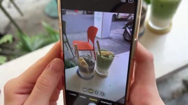 Matcha Muz Kola Genç Etkilenen Sosyal medya için akıllı telefonlu kek fotoğrafları çekiyor. Yüksek kalite 4k görüntü