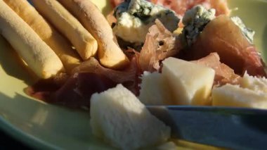 Şarküteri tahtasından eritilmiş peynir, kraker, turşu, köfte ve antipasto.