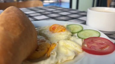 Tahta Masa 'da Kahvaltı Tabağı' na kızarmış yumurta ekleme görüntüsü. Yüksek kalite 4k görüntü