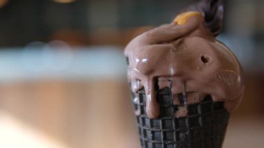 Açık gri arka planda dönen waffle külahlı çikolatalı dondurma topunu kapat. Yaz tatlısı. Yüksek kalite 4k görüntü