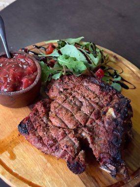 Üst tabakta biftek ve beyaz arka planda izole edilmiş çatal bıçaklı karışık salata. Yüksek kalite fotoğraf