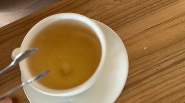 Sabahları çay, içecek, tatlı ve bitkisel çay, bardağa sıcak su dökmek, bardakta beyaz şeker, susadığında rahatlamak için şeffaf bardakta içki konsepti. Yüksek kalite 4k görüntü