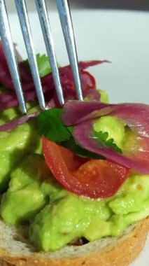 Şef taze yeşillikler, mantarlar ve baharatlarla süslenmiş lezzetli bir avokado tostu sunarak sağlıklı ve görsel olarak çekici içerikleri vurguluyor. Yüksek kalite 4k görüntü