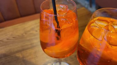 Barmenin bir bar kaşığıyla karıştırdığı ferahlatıcı portakal kokteyli aperol spreyinin yakın plan çekimi. Kapatın. Ağır çekim. Yüksek kalite 4k görüntü