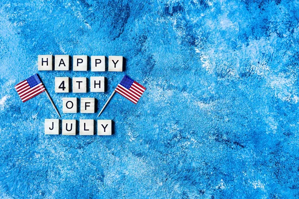 the inscription July 4 in wooden letters on a blue background. Design of the inscription for American independence Day. Background template for greeting cards, posters, leaflets and brochures.