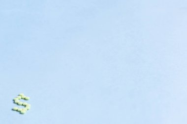 Tabletler mavi arka planda dolar işareti şeklinde. Mavi arka planda vitamin tabletleriyle yapılan dolar işareti kavramı. kopyalama alanı. Yumuşak odaklı, bulanık arkaplan. Metin için boşluk.