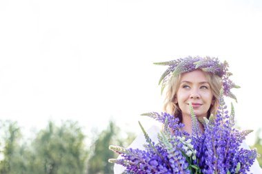 Güzel, mutlu bir kız bir çayırda lup tarlasının tadını çıkarıyor, açık havada dinleniyor, eğleniyor, bir bitki tutuyor. Uyum, mutluluk, keyif, özgürlük kavramı. Mesajlaşmak için bir yer. Boşluğu kopyala,