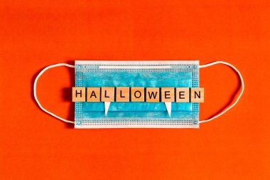 Cadılar Bayramı 'nı siyah arka planda tıbbi koruyucu bir maskeyle kara kağıttan yapılmış yarasa siluetleri ile yeni bir gerçeklikte cadılar bayramı 2020. Düz plan. Dizaynınız için düz konum