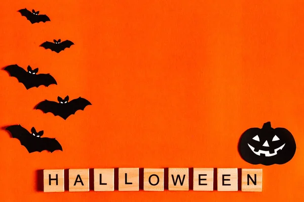 Letras de Halloween sobre fondo naranja con siluetas de papel negro, murciélagos, calabaza, araña. El concepto de Halloween. la vista desde la parte superior —  Fotos de Stock