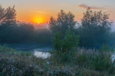 Sabah sisi nehirde, güneş ışınları suyun üzerinde yükseliyor.