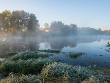 Sonbahar sabahında ağaçlarla birlikte nehrin üzerinde güzel bir gün doğumu..