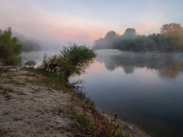 morning sunrise over the river in the fog in the autumn forest