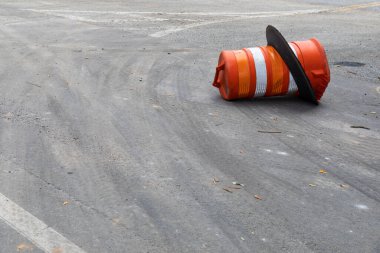 Yan tarafında turuncu trafik varili olan asfalt sokak yüzeyi, güvenlik ve yol tehlikesi, kopyalama alanı, yatay görünüm