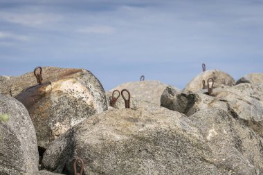Gökyüzünün arka planına karşı büyük taşlar ve kayalar. Deniz kıyısındaki büyük taşların dalgalanması. 