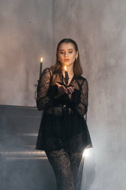 Siyah dantelli gizemli kadın dumanlı, gotik bir ortamda klasik bir piyanonun yanında poz veriyor. Yüksek kalite fotoğraf
