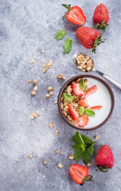 Bir kase yoğurt, granola ve çilek en iyi görünümü gri taş masada 