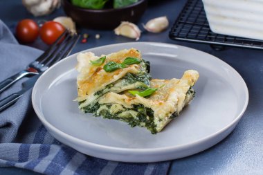 Ricotta peyniri ve mavi taş concreet tablo arka plan üzerinde ıspanak ile lezzetli ev yapımı lazanya. Vejetaryen yiyecekler. Italyan Mutfagi