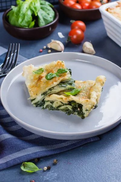 Ricotta peyniri ve mavi taş concreet tablo arka plan üzerinde ıspanak ile lezzetli ev yapımı lazanya. Vejetaryen yiyecekler. Italyan Mutfagi