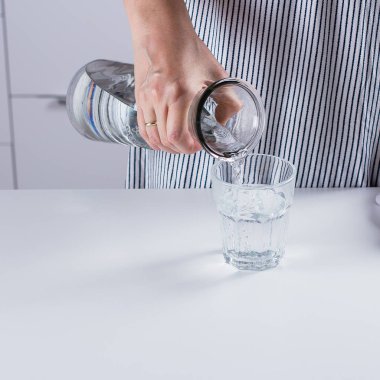 Cam mutfak içine su sürahi dökme kadın