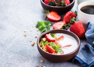 Yoğurt, müsli ve gri beton tablo arka plan üzerinde çilek granola ile kahvaltı. Sağlıklı Vegan temiz diyet gıda kavramı. Görünümü ana sayfa, yer kopyalayın, yat
