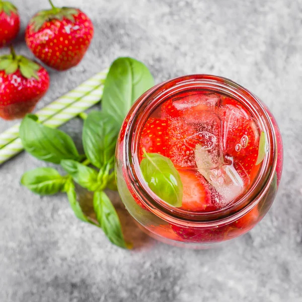 Top view of Summer Food and Drink. Mason Jar with strawberry basil lemonade on concrete table. Copy space, square image