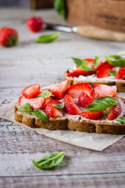 Süzme peynir, fesleğen ve eski püskü ahşap masa arka plan, üstten görünüm, kopya alanı kagit üzerinde çilek çilek bruschetta