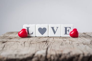 Sevgililer günü kart kavramı. Yaratıcı bir fikir. Aşk mesajı yazılı eski ahşap arka plan üzerinde ahşap bloklar ve Seramik kırmızı kalp.