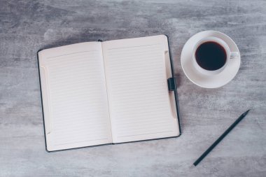 İş, natürmort, eğitim, ofis, banka donatımı veya planlama kavramı: Top görünümü veya düz yatıyordu açık defter ile boş sayfaları ve tablo arka plan üzerinde kahve fincanı görüntüsünü hazır eklemek için veya yukarı alay