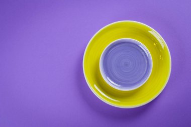 Renkli mor ve sarı tabakların mor arka plandaki tabloda. Üstten görünüm, kopya alanı