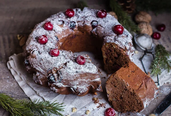 Holiday dessert. Traditional homemade christmas chocolate cake with cherry on wooden table background with festive decoration. Rustic style.