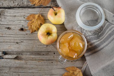 Ev yapımı elma reçel ya da sos kavanoz masada. Ahşap rustik arka plan kopya alanı, üstten görünüm