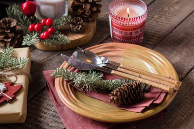 Noel ayarı tablo. Yemek tabağı, gümüş, çam ağacı, hediye kutusu, mum ve şenlikli dekorasyon. Tatil gıda kavramı.