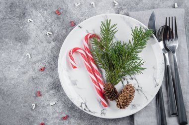 Noel Sofra ağaç çam dalları, peçete, çatal, bıçak, kaşık, baston şekerler ile yer. Noel tatil arka plan. Yat, görünümü, kopya alanı Top