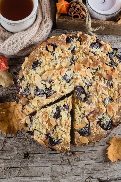Cozy Autumn Food. Homemade autumn cake with nuts and plums on wooden background, Top view, copy space.