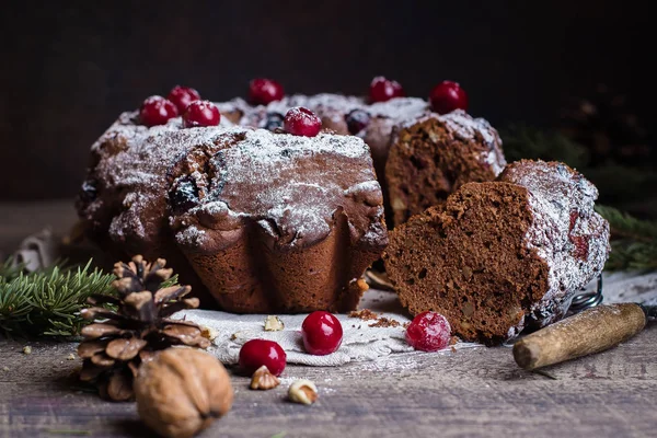 Holiday dessert. Traditional homemade christmas chocolate cake with cherries on wooden table background with festive decoration. Rustic style.