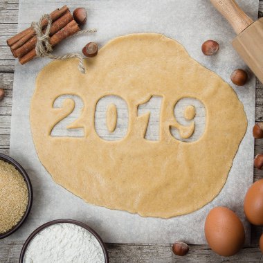 Fırın malzemeleri, yumurta, un, kahverengi şeker, tarçın ve oklava. Tatil kurabiyeleri, yeni yıl kutlama için fırın. Çiğ hamur gingerbreads şekil 2019 pişirme için hazır.