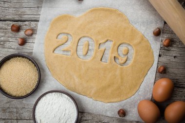 Fırın malzemeleri, yumurta, un, kahverengi şeker, tarçın ve oklava. Tatil kurabiyeleri, yeni yıl kutlama için fırın. Çiğ hamur gingerbreads şekil 2019 pişirme için hazır.