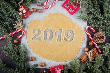 Tatil kurabiyeleri, yeni yıl kutlama için fırın. Çiğ hamur gingerbreads şekil 2019 pişirme için hazır. Noel masa dekorasyon ve köknar dalda