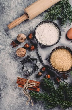 Malzemeler için Noel yemek pişirme - un, kahverengi şeker, yumurta, baharatlar ve tatil dekorasyon karanlık taş zemin üzerine. Kopya alanı ile üstten görünüm.