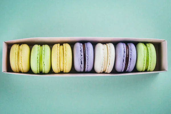 Pastel Macaron Macarrón Caja Papel Sobre Fondo Verde Desde Arriba — Foto de Stock