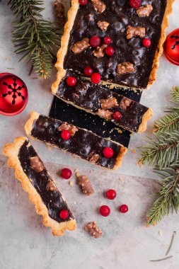 Gri tablo arka plan üzerinde Noel tatili için kızılcık ile çikolatalı tart.
