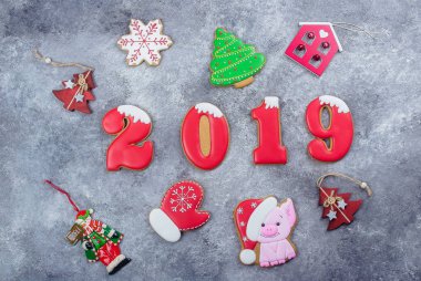Noel, yeni yıl 2019 kart kavramı. Zencefilli bisküvi numaraları 2019 ve sembol yıl - şeklinde taş beton gri arka plan üzerinde domuz. Üstten görünüm. Düz Lay.