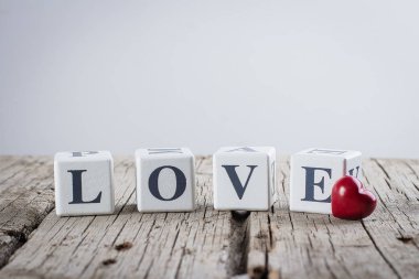 Sevgililer günü kart kavramı. Yaratıcı bir fikir. Aşk mesajı yazılı eski ahşap arka plan üzerinde ahşap bloklar ve Seramik kırmızı kalp.