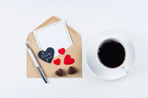 バレンタインの日のモックアップ 愛のカードです コーヒー カップ チョコレート菓子と紙カード封筒白いテーブルの上 フラット横たわっていた トップ ビュー スペースのための場所 — ストック写真